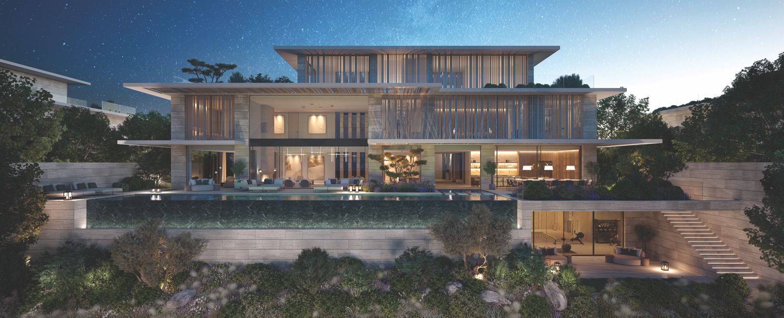 Hillside mansion with an infinity pool lit up at night