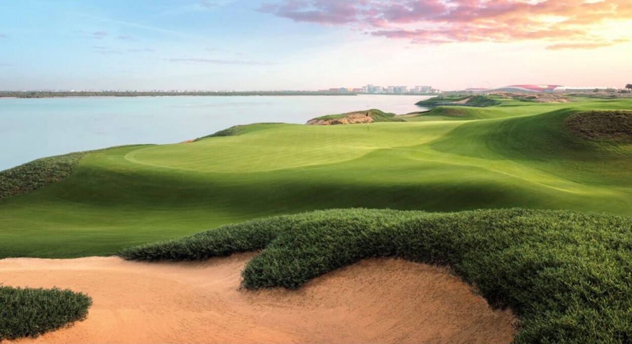 Coastal golf hole with a bunker and flagstick beside the water